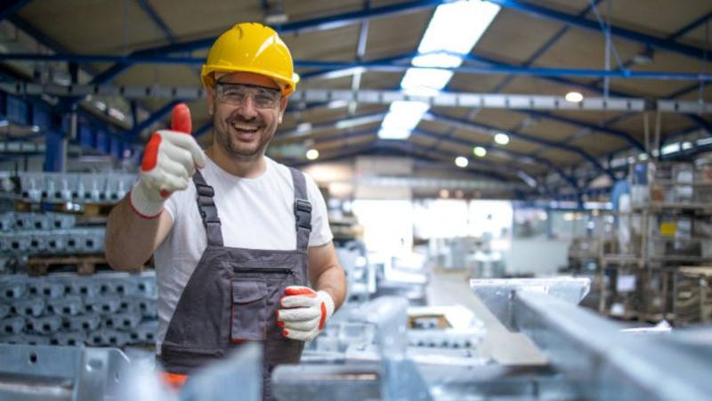 Arbeiter mit Helm in Fabrikhalle Arbeiter mit Helm in Fabrikhalle