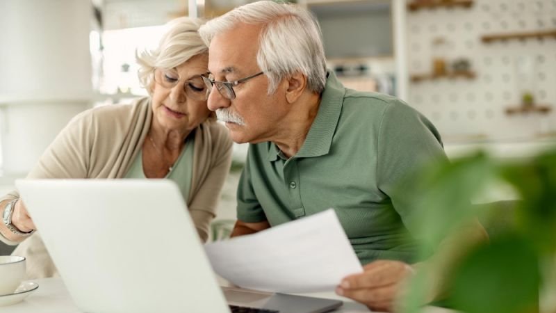 Älteres Ehepaar mit Steuererklärung vor Laptop Älteres,Ehepaar,Laptop,Steuerklärung