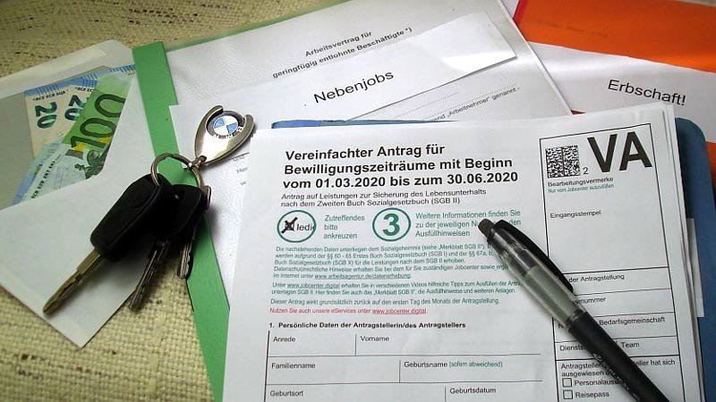 Schummeln bei Sozialleistungen zieht Strafe nach sich. ALG II-Antrag,Geld,Autoschlüssel
