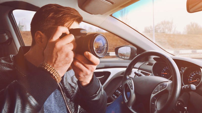 Mann überwacht mit Kamera Mann,Auto,Kamera,Überwachung